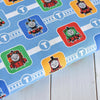 Thomas the Tank Engine on blue fabric with square badges on train track lines - Craft Cotton Co