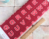 Red fabric letters on a red cotton fabric panel - Lewis and Irene
