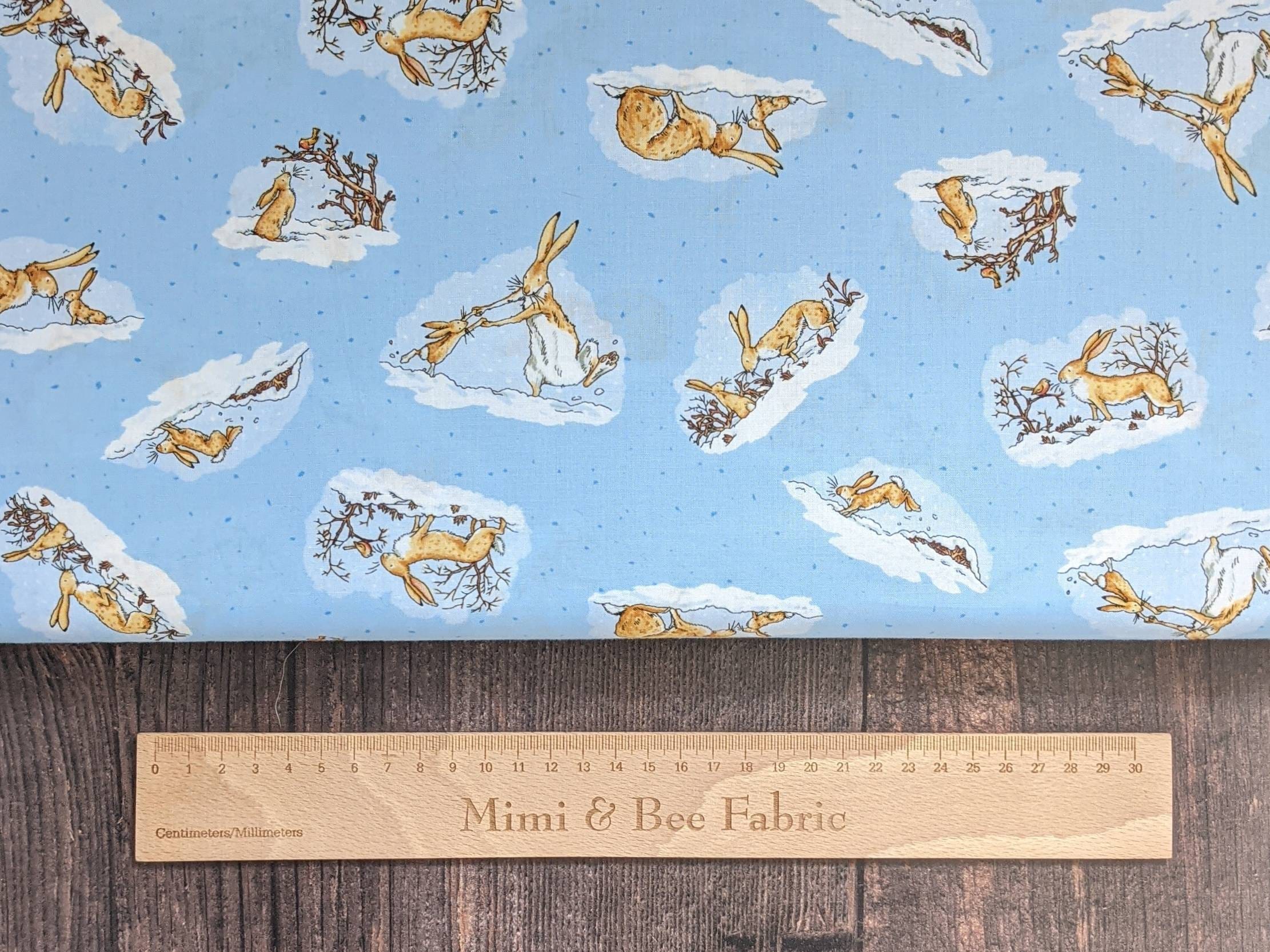 blue guess how much I love you cotton fabric with mumy hare and baby hare in the snow by Clothworks