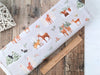 Black bears, skunks, foxes, rabbits, squirrels and deer in the snowy forest on light grey cotton